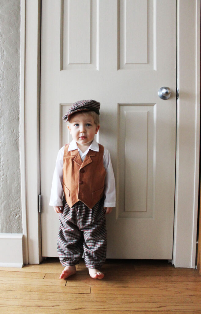 toddler boy standing by white door