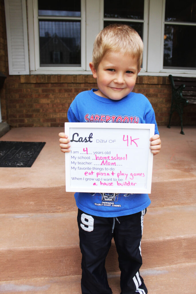 young boy holding homeschool year sign