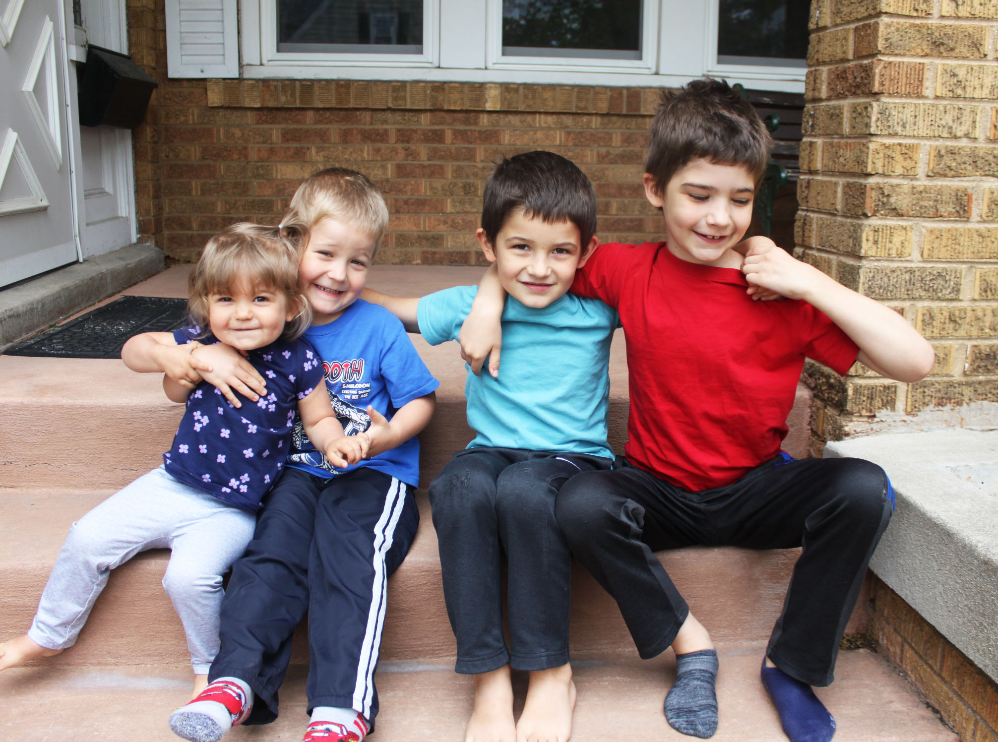 four homeschool children sitting on the porch