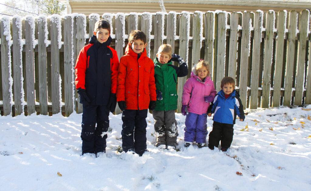 five homeschool kids standing in the snow