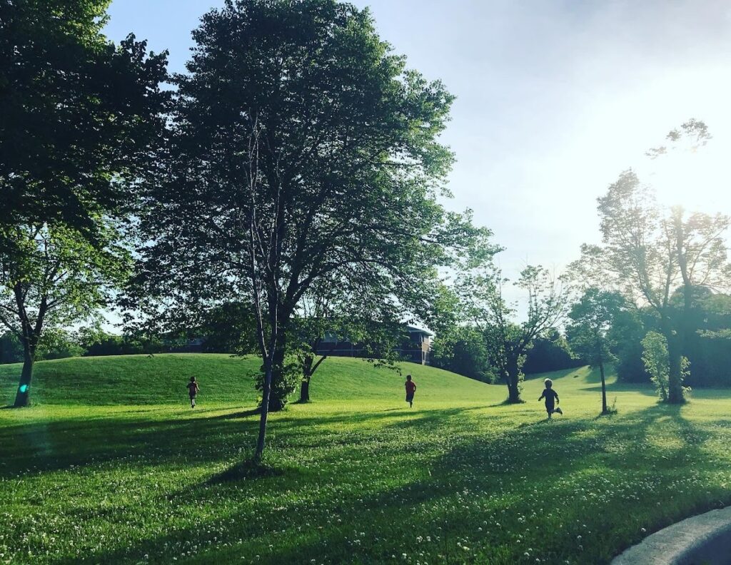 four homeschool children running through the grass