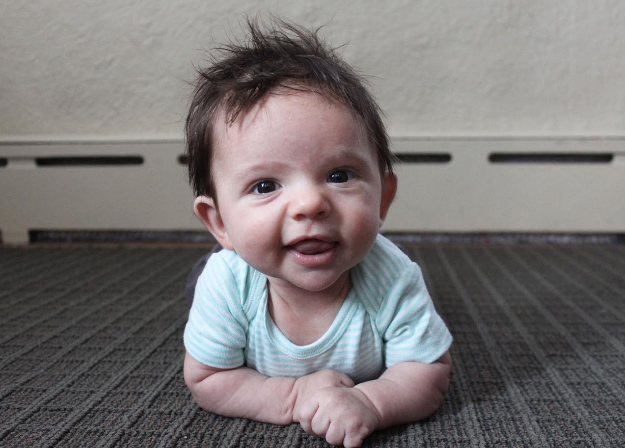 young baby boy lying on rug