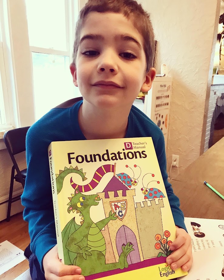 homeschool boy holding phonics curriculum