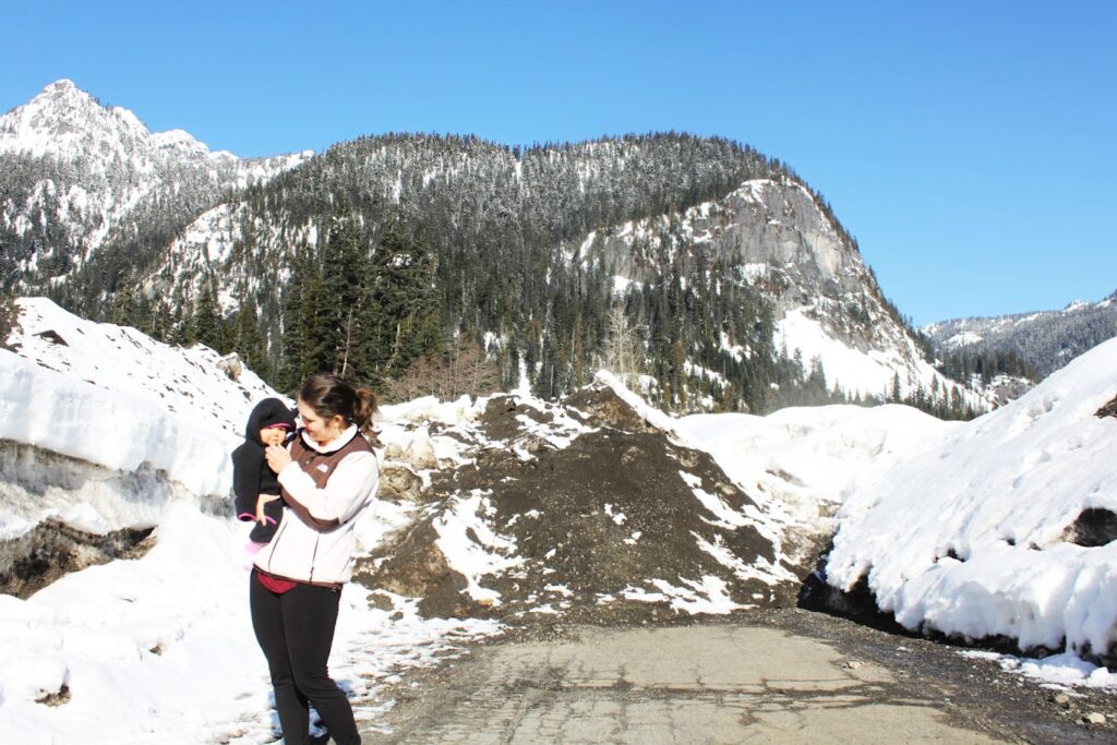 mom and baby in the snow in the mountains