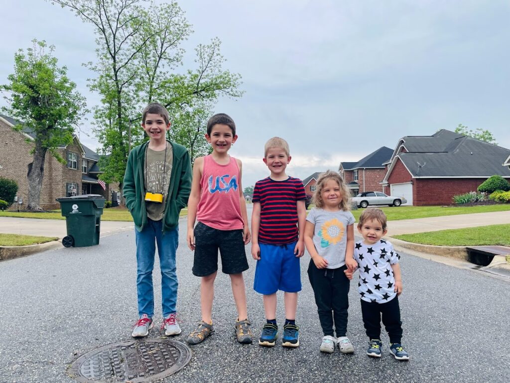 five homeschool children standing in the street