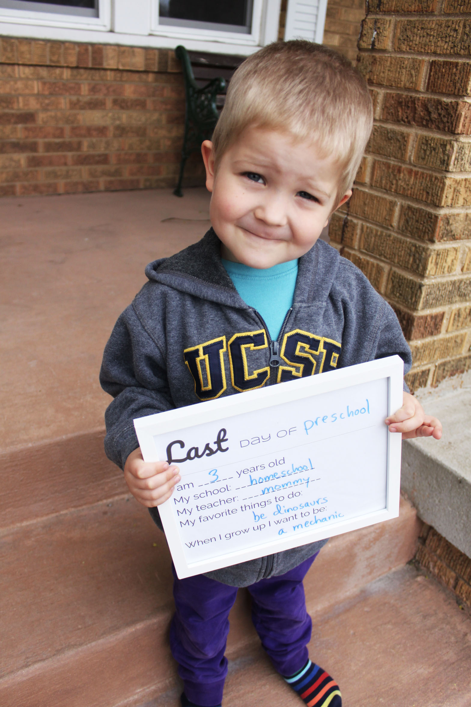 preschool homeschool boy holding last day of school sign