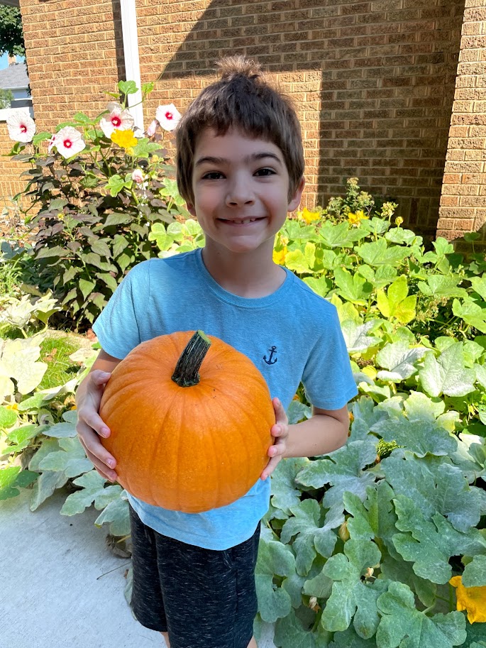 homeschool boy holding pumpkin