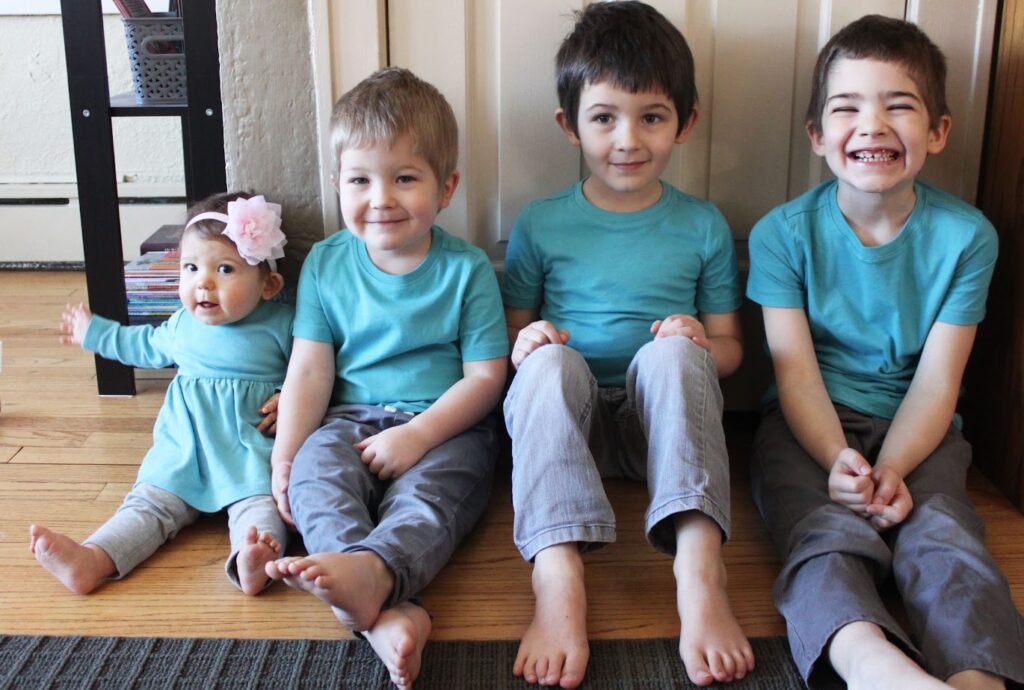 four homeschool children wearing matching teal shirts