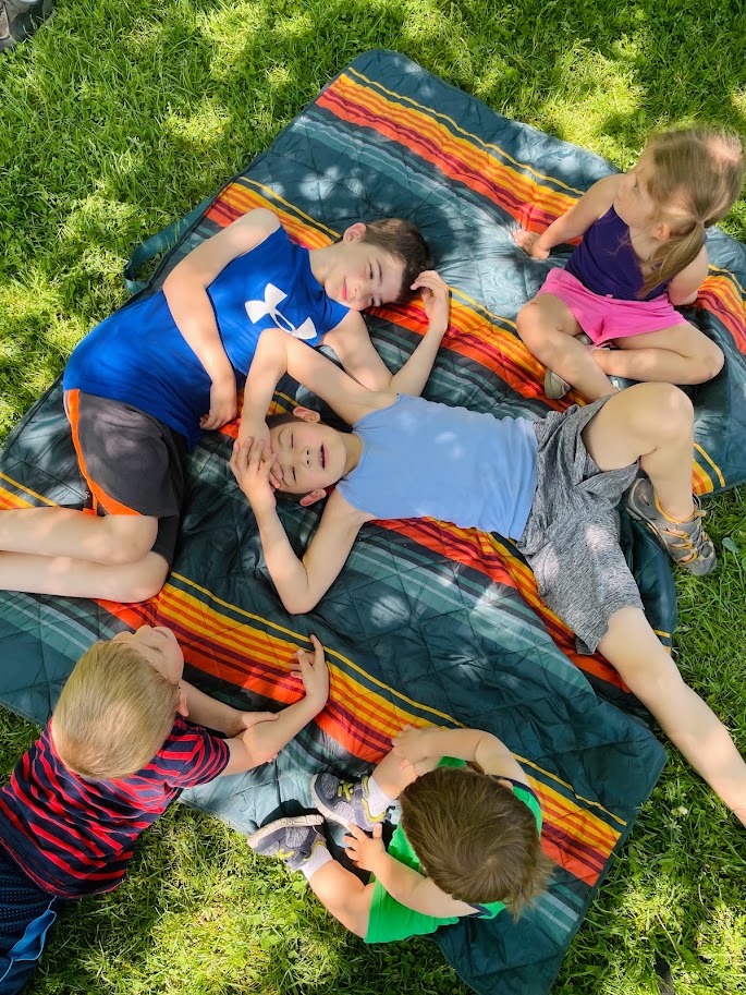 my homeschool children outside on a blanket