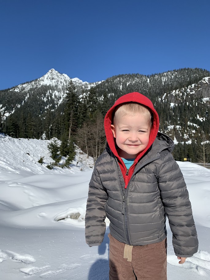 small boy in the snow on a road trip