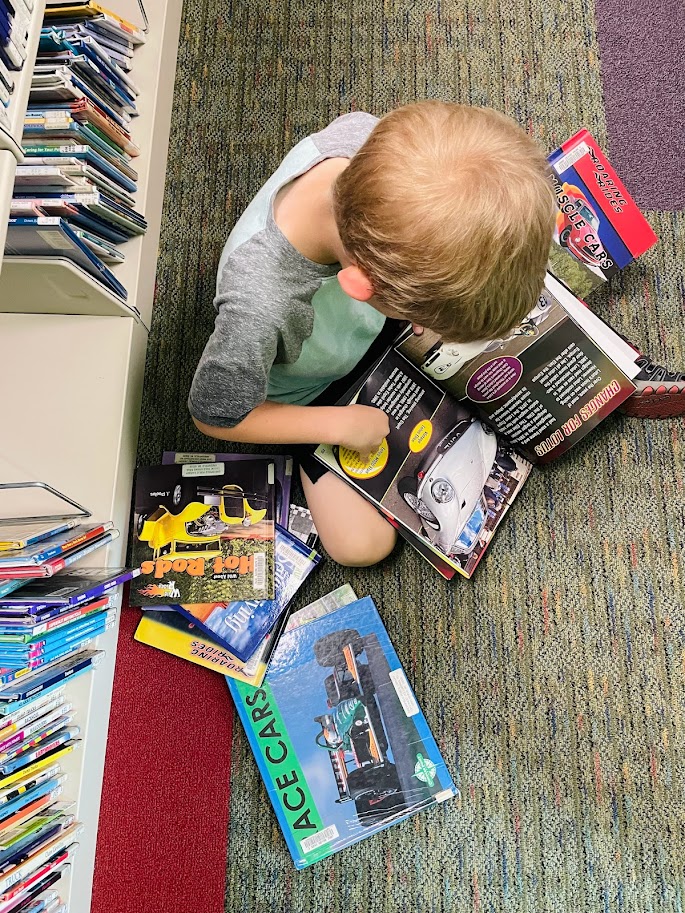 homeschool boy reading books at the library