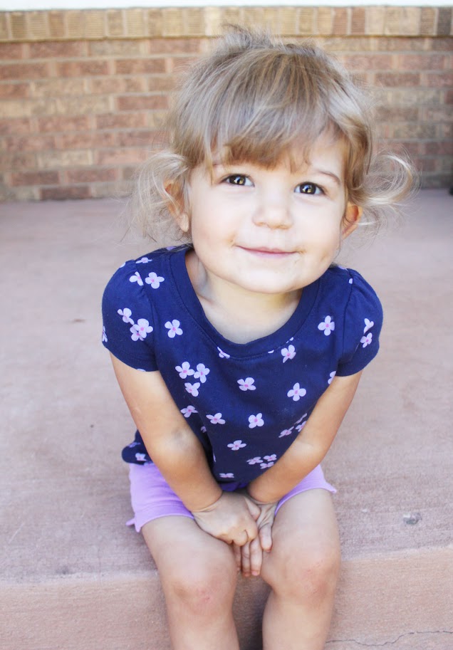 toddler girl sitting on porch