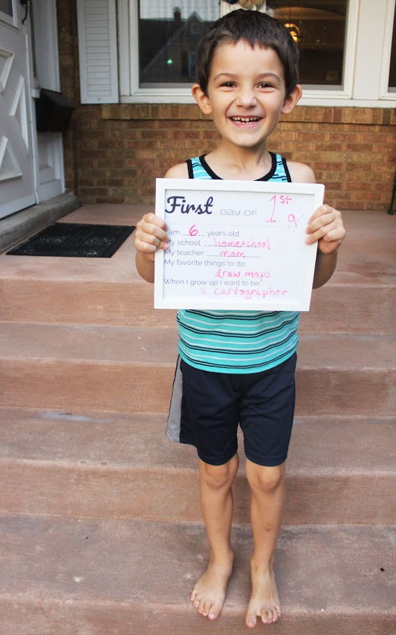 homeschool boy holding back to homeschool sign