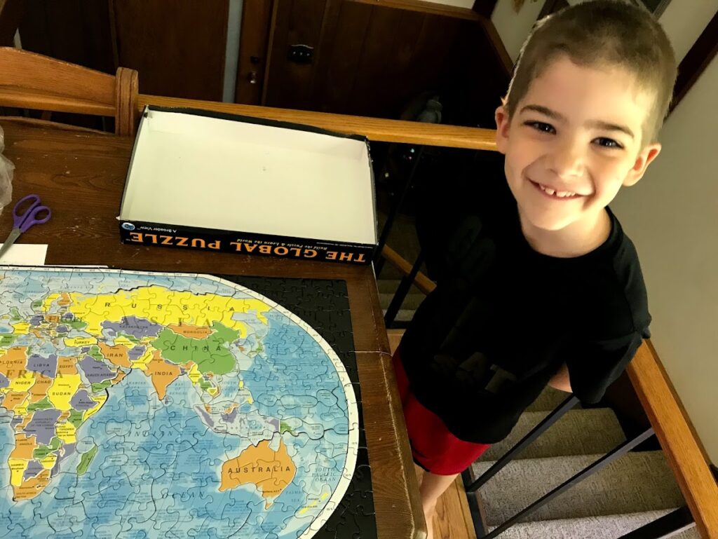 homeschool boy with world geography puzzle