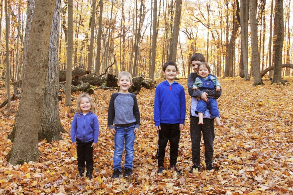 five homeschool children in the woods