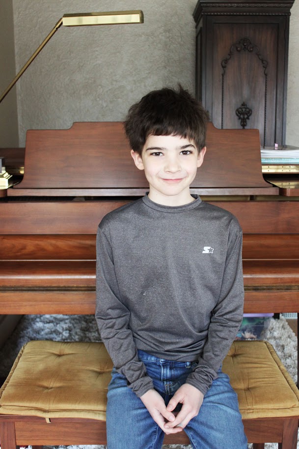 homeschool boy sitting near piano