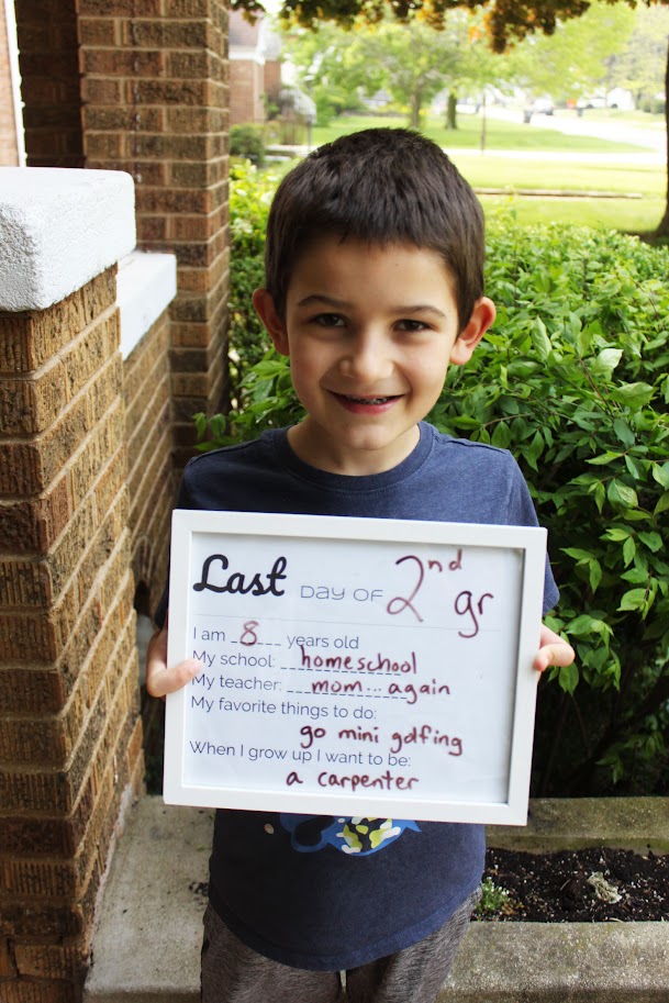 boy holding last day of homeschool sign