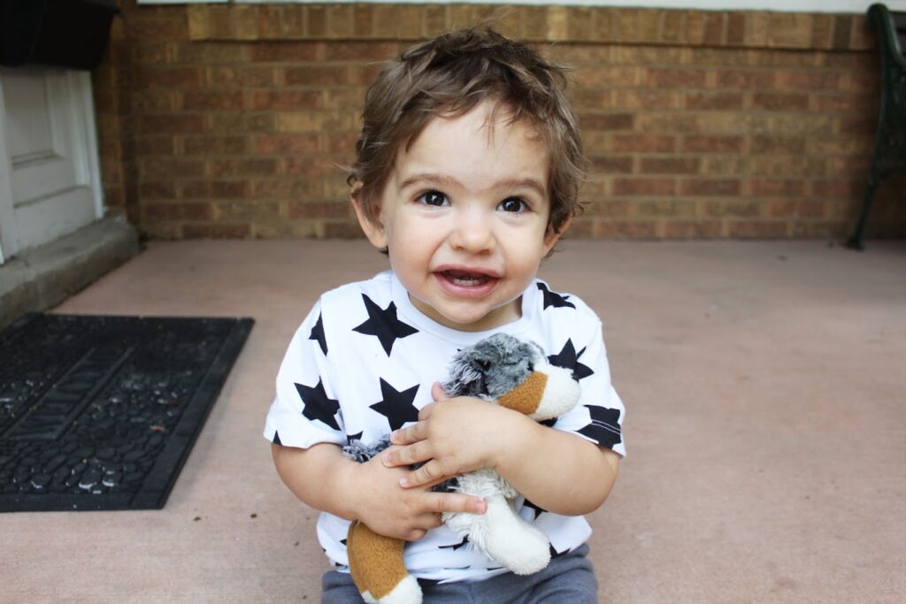 baby boy holding stuffed dog