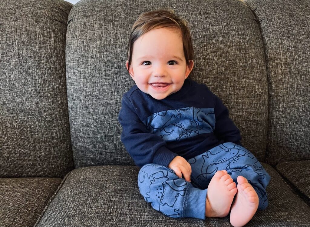 baby boy in his first year sitting on couch