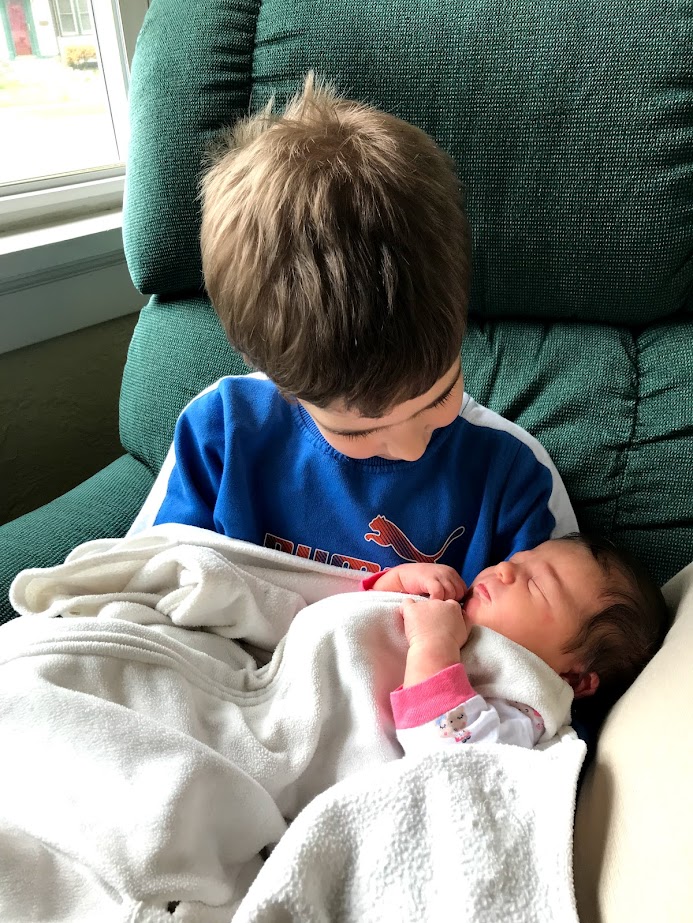 homeschool boy holding newborn baby girl