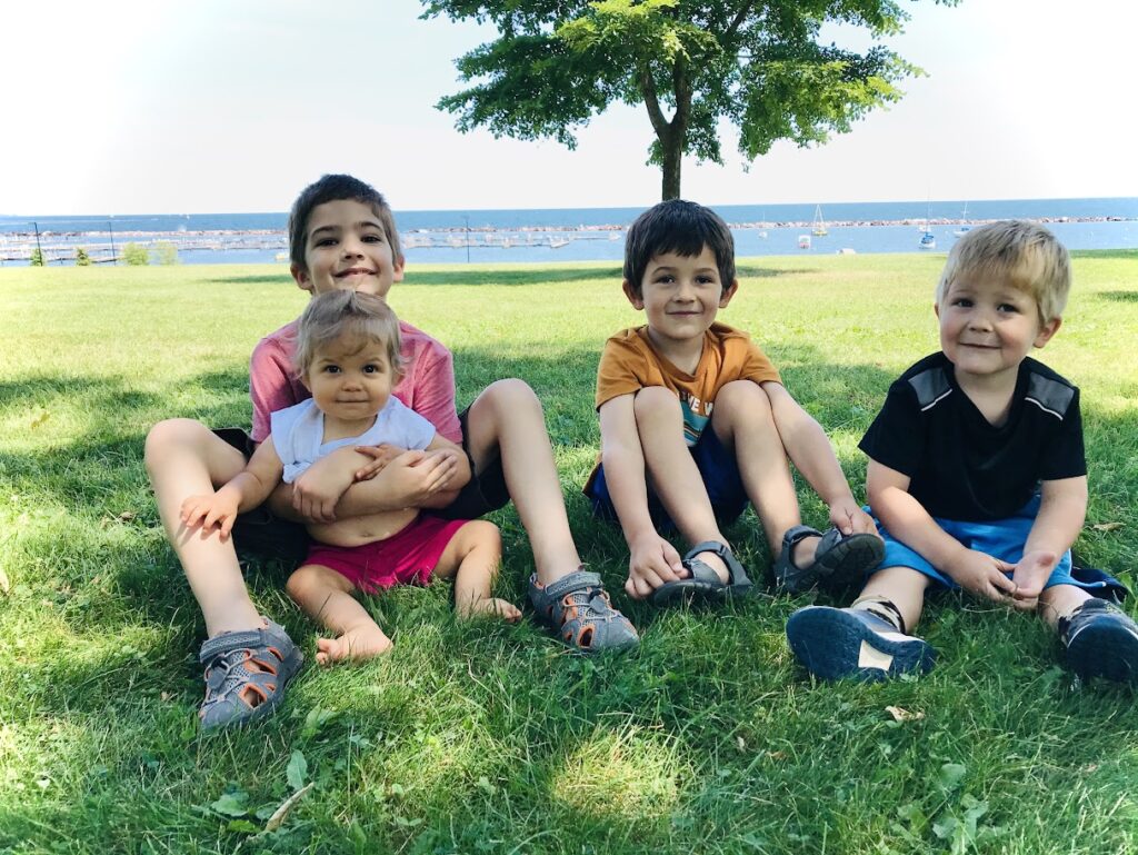 four homeschool children sitting in the grass