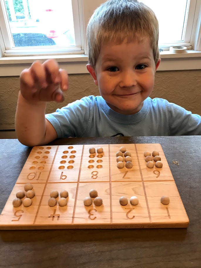 young homeschool boy counting wooden balls