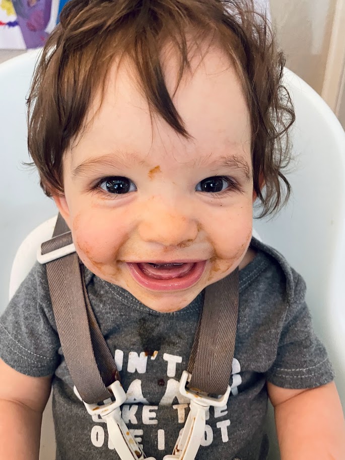 baby boy in high chair with messy face