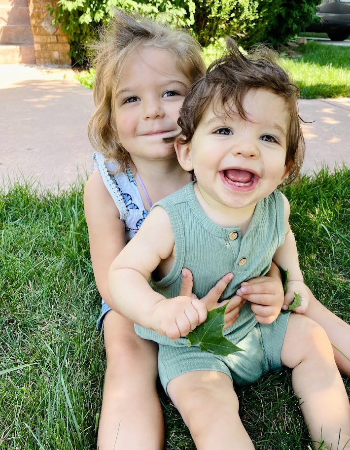 toddler girl holding baby brother