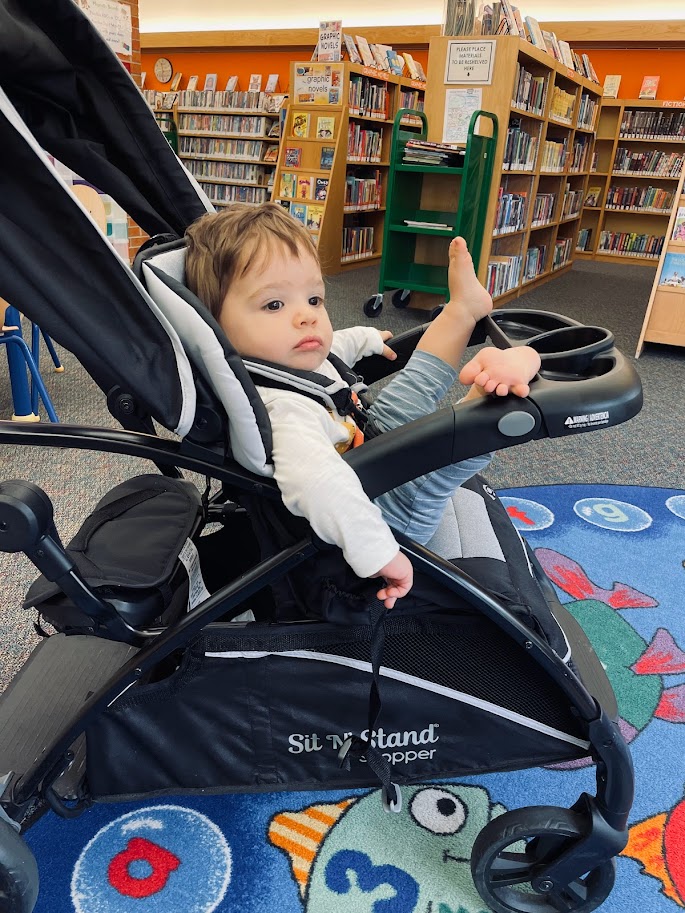 baby boy sitting in stroller at the library