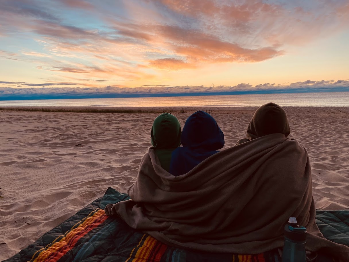 three homeschool boys watching a sunrise at the beach