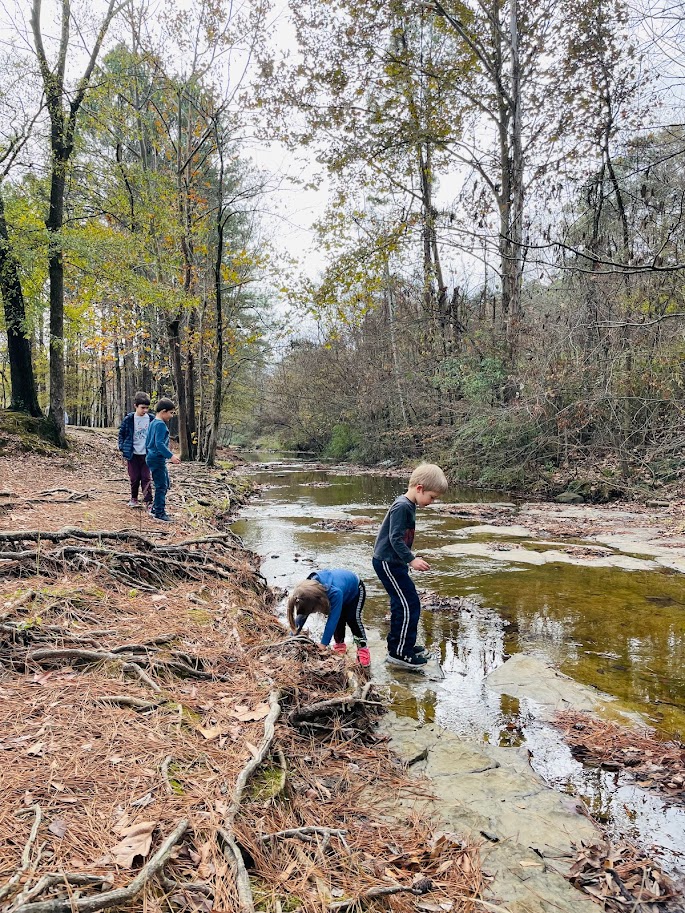 four children exploring a river