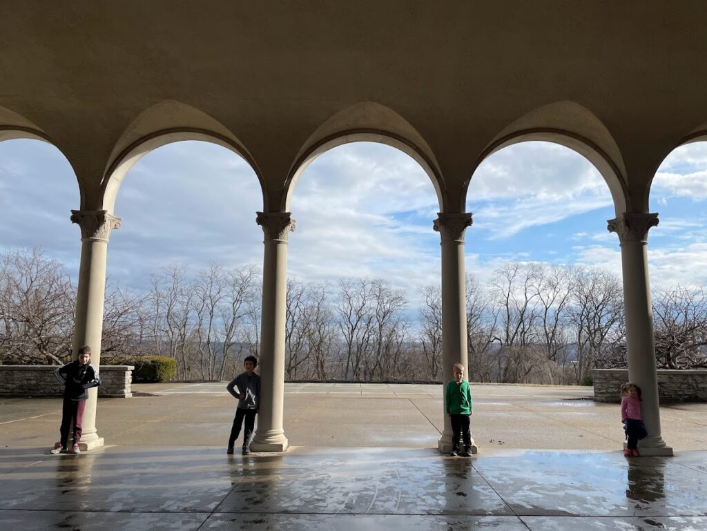 homeschool children standing near arches