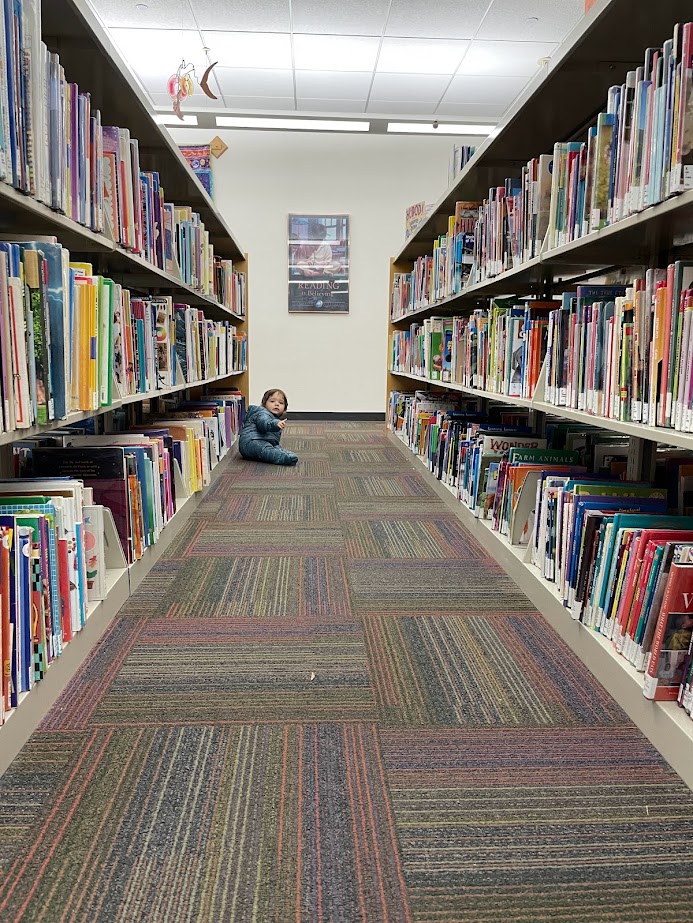 baby crawling through the library