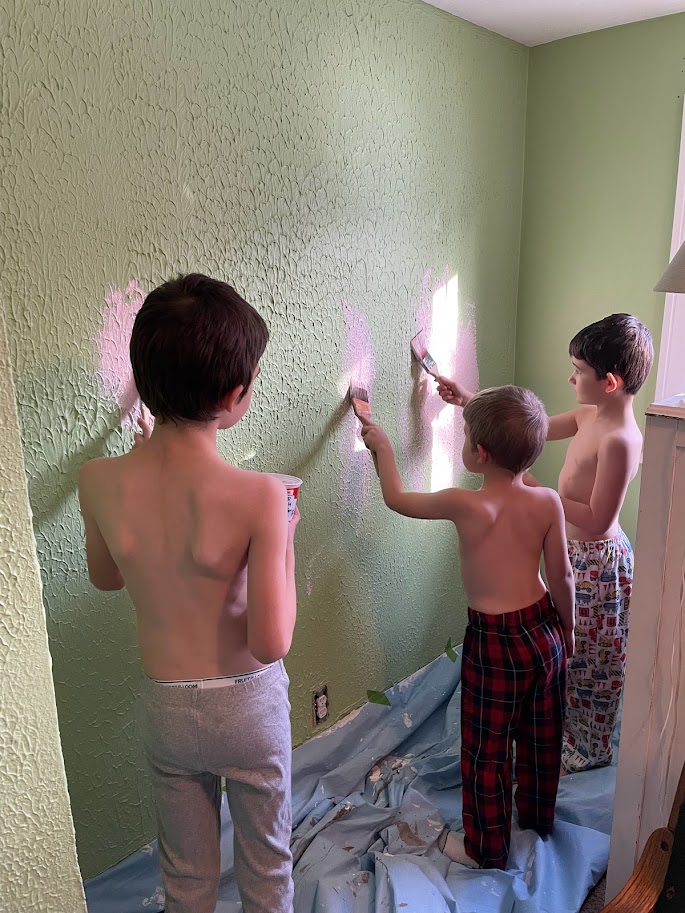 homeschool boys painting a wall