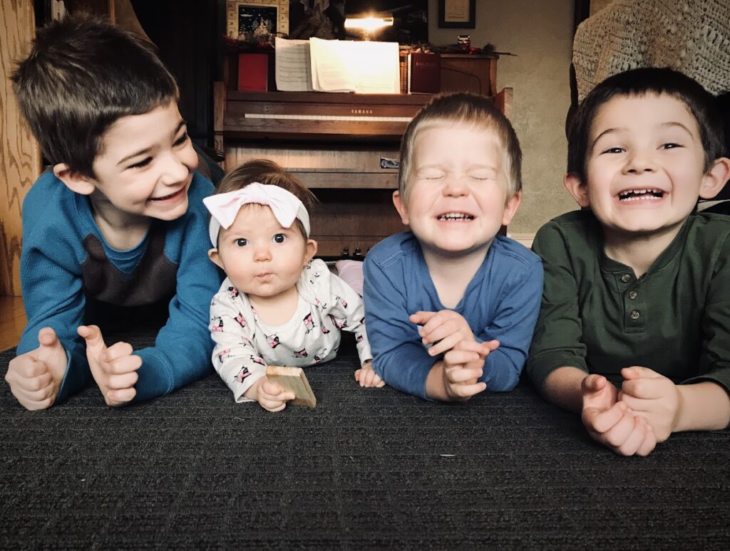 four homeschooling children lying on the floor