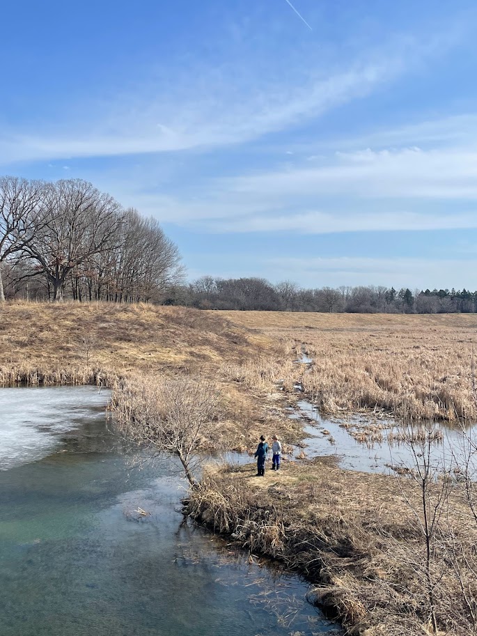 two homeschool boys playing near a pond