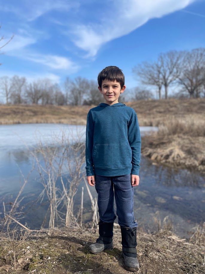 homeschool boy standing by a pond