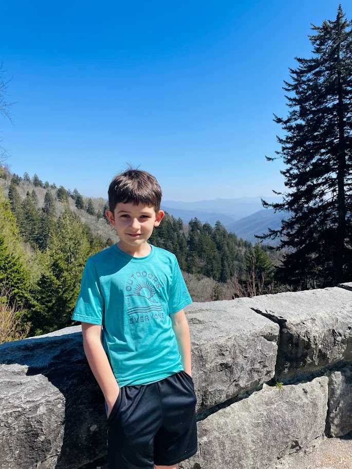 homeschool boy standing outside near mountains