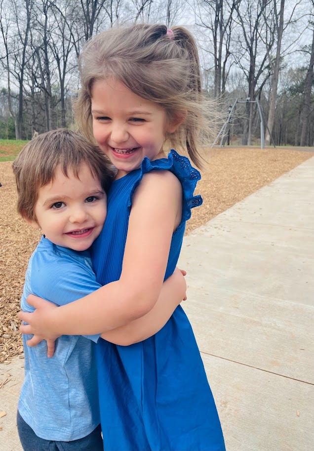 homeschool sister and toddler brother hugging