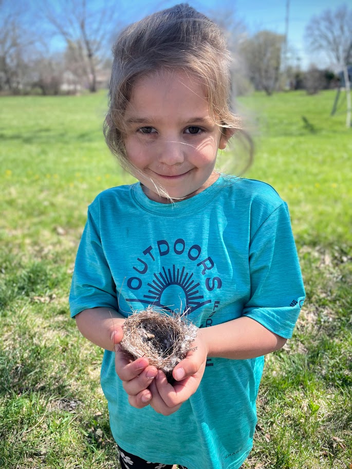 young homeschool girl holding bird nest