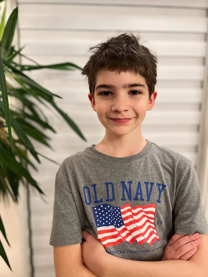 portrait of a homeschool boy near indoor palm tree