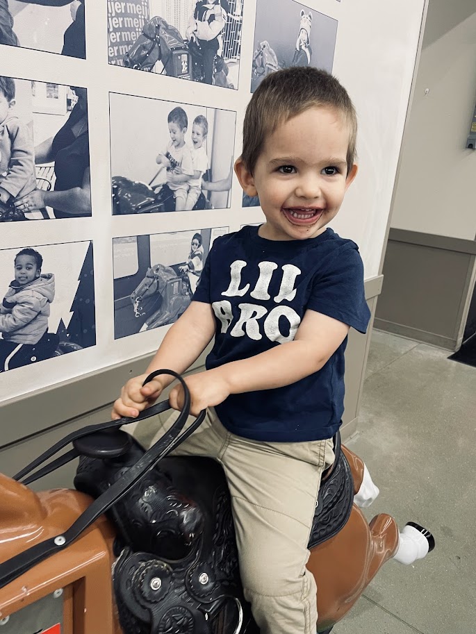 toddler boy riding plastic horse