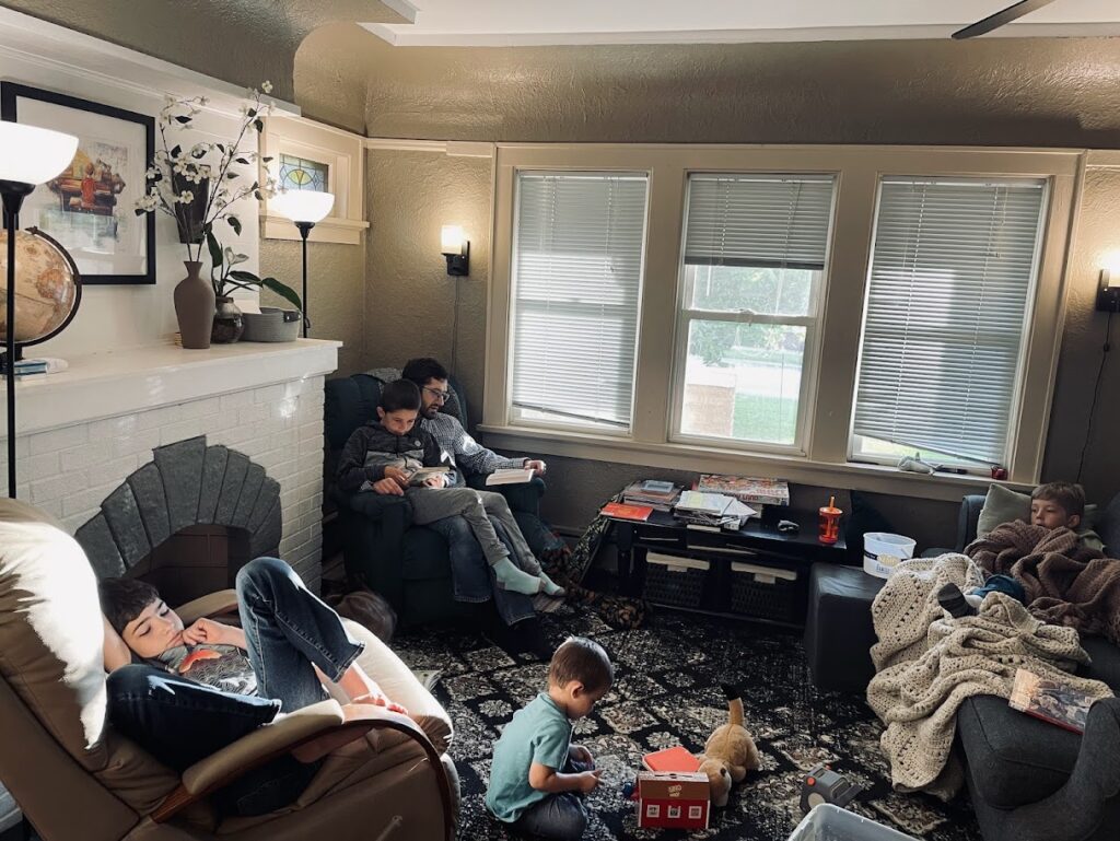 dad reading aloud to five homeschool children in the living room