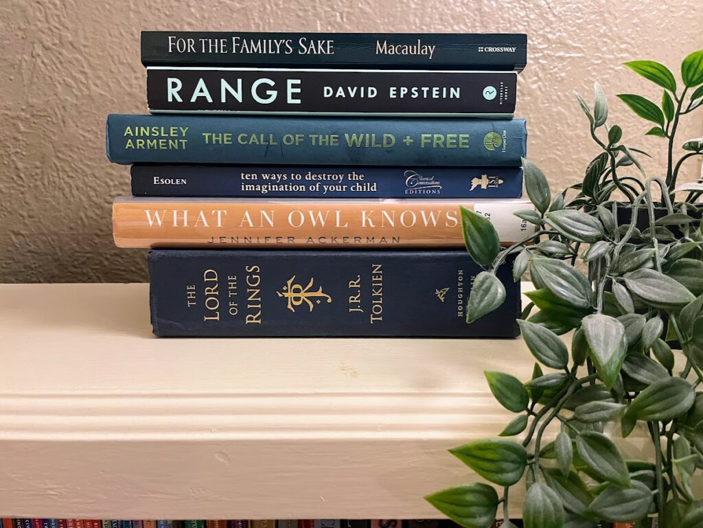 six books in a stack on a bookshelf