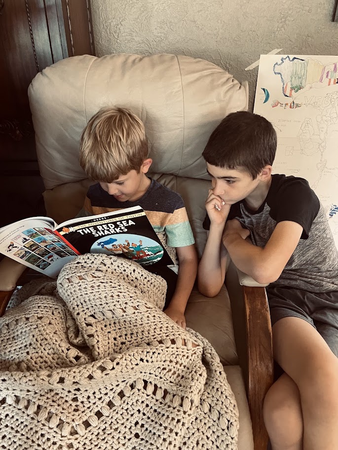 two homeschool boys reading a book together