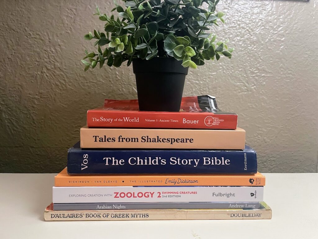 stack of books for our homeschool routine for multiple ages