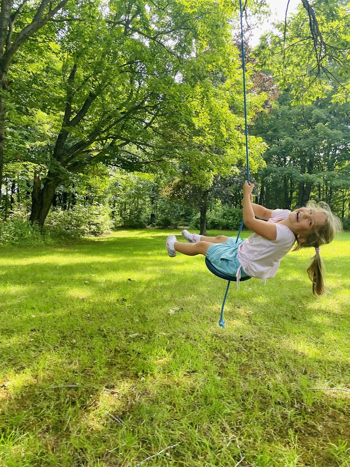 homeschool girl learning to swing on a tree swing