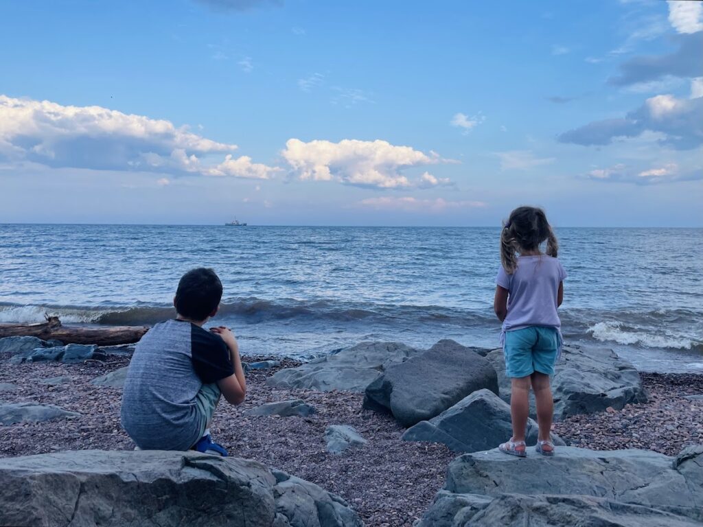 homeschool boy and girl watching a ship on lake superior