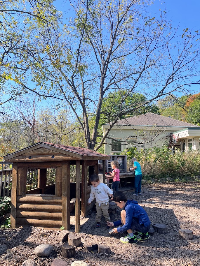 four homeschool children playing outside at a nature playground