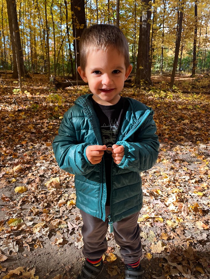 homeschool toddler boy standing in the woods in the fall